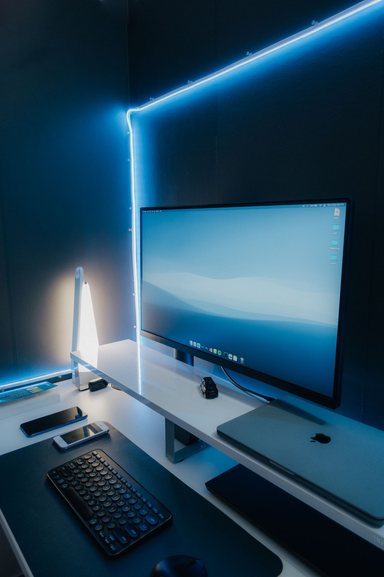 Moderne computerwerkplek met monitor, toetsenbord en laptop